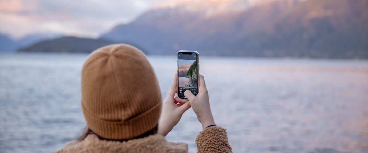 Woman taking photo by a lake